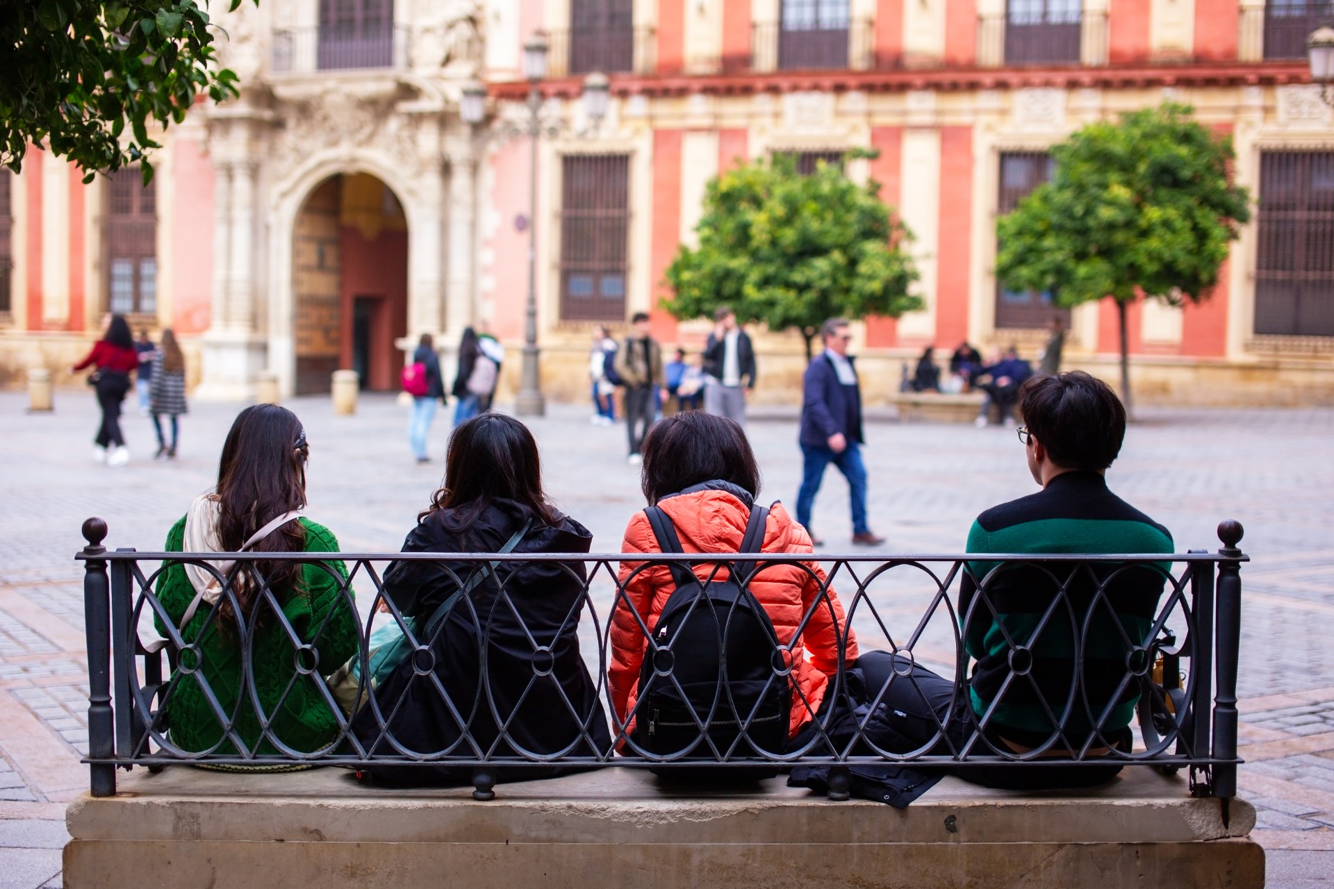 Studierende entspannen auf einer Bank auf einem Platz in Sevilla